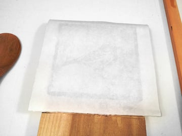 carefully place your paper face down onto the wood