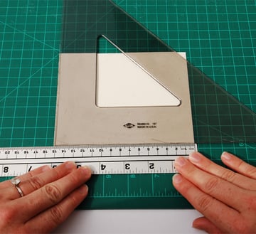 Place the ruler 1cm away from one of the long sides