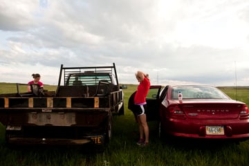 Charity Miles stretches by her car Saturday morning before everyone loads onto the bus that will take them to the half marathon's starting line. This is her second year running the race and usually runs on the road as a normal route, but says it's hard for people not from Valentine to realize how close it is to people's homes. "You can always tell the people that are not from the area and are going up to Merritt Dam because they drive very, very fast and they look at you like you’re crazy for running out in the middle of nowhere and you can tell that they’re wondering how far you’ve been running because they thought the last town was 45 minutes away."