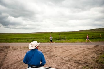 Craig Miles watches as his daughter passes by during the half-marathon.