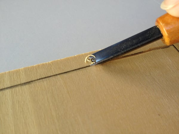 use the V-shaped gouge to carve against the grain