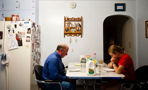 Charity Miles and her father Craig Miles pray before breakfast the morning of the Sandhills marathon. French toast for breakfast is a tradition that has been carried in their family before sporting events since Charity was in high school.